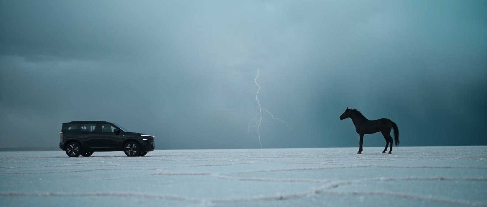 The Sierra and a black Marwari horse on the white salt of Kutch, lightning behind